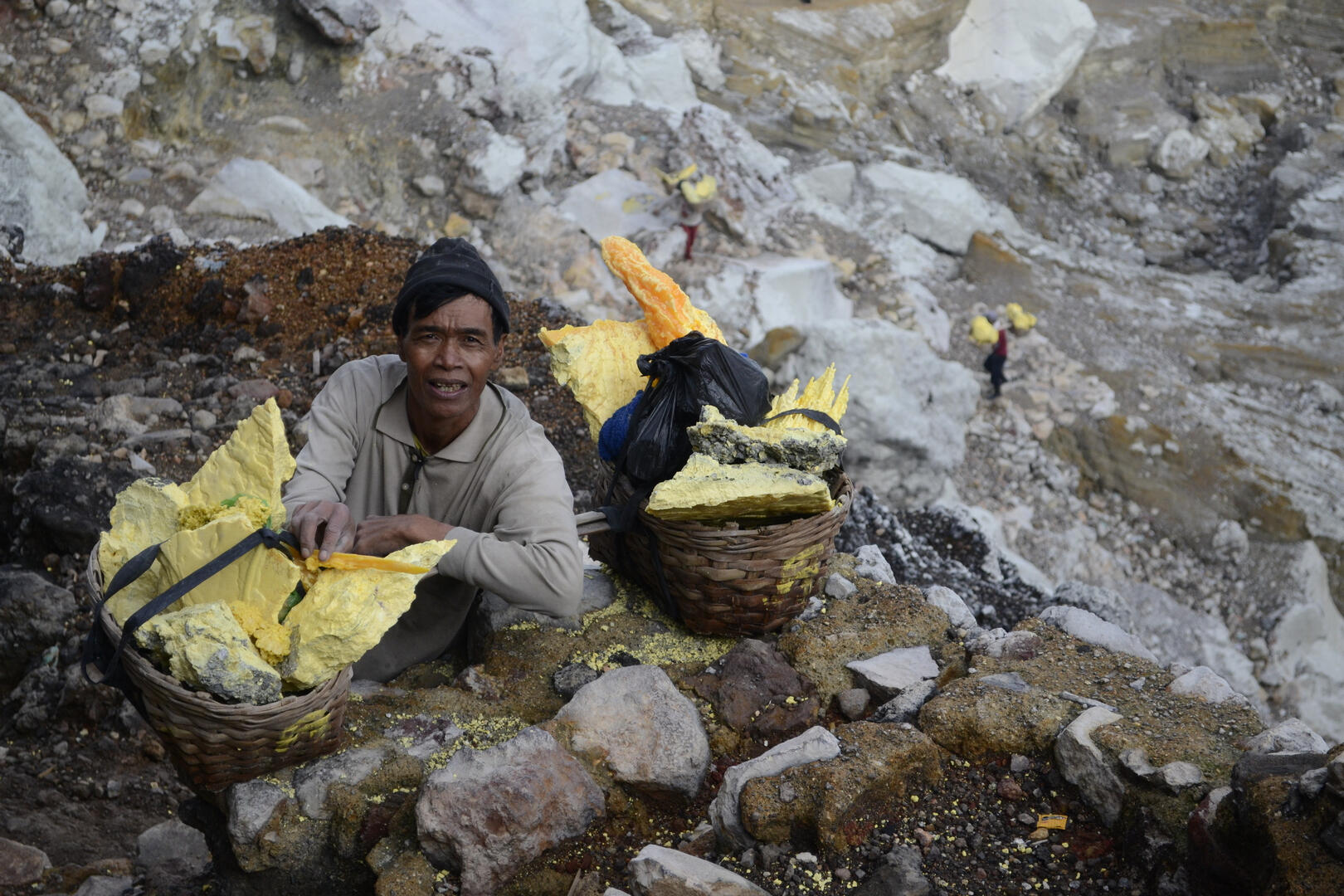 Indonesian worker carries sulfur from the vent of the Ijen volcano